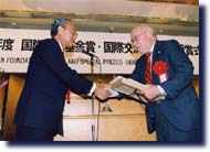 Photo of President Fujii presented the award certificates to Gibney