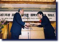 藤井理事長よりアイリーン･ヒラノ氏へ賞状を授与する写真