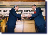 Photo of President Fujii presented the award certificates to Mr.Tuncoku