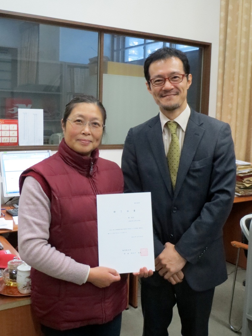 The Japan Foundation staff member brought Liu (left) a diploma of the training program for librarians.