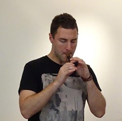 雅楽で使われる楽器「篳篥（ひちりき）」を演奏するジョライ氏の写真