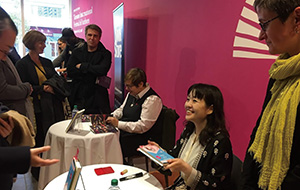 Photo of Sayaka Murata signing a book at the Toronto International Festival of Authors (TIFA)