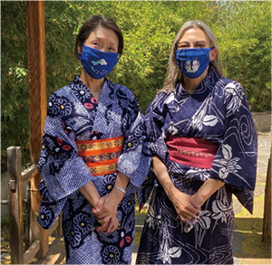 Photo of the two women in yukata wearing the winning design masks