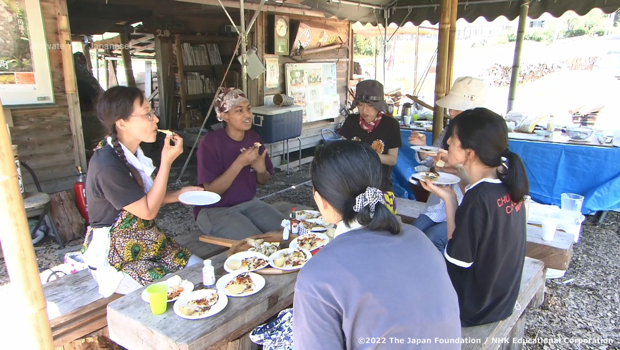 Picture of a scene showing a conversation with members of the local community as they have a meal outside 