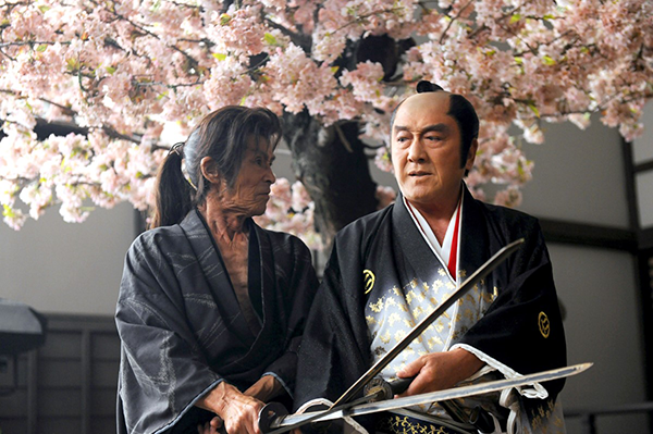 Two male actors are clashing swords.