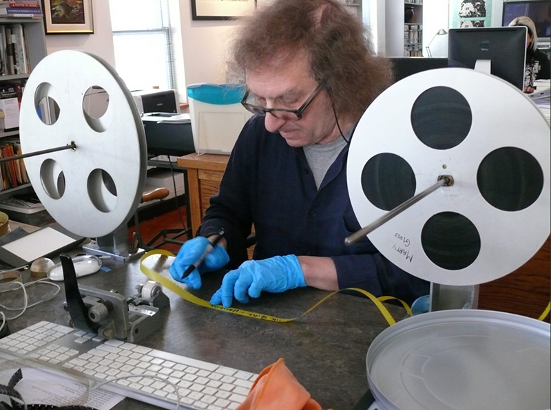 マーティ・グロス氏が作業場で映画フィルムを修復している。