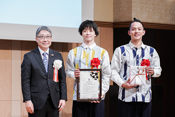2024年度地球市民賞 授賞式にて、んまつーポス2名と男性1名がこちらを向いている。
