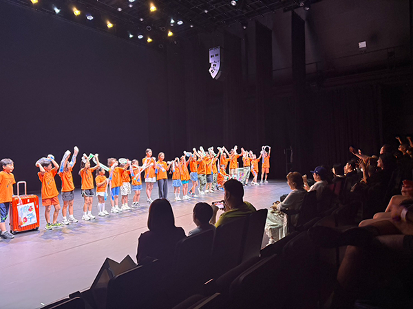 空港ロビーにて、国際子どもダンスキャンプ参加者11名が写っている。
