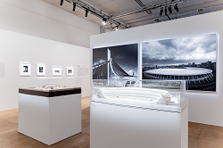 「丹下健三と隈研吾　東京大会の建築家たち」展示風景。国立代々木競技場建築模型と外観写真、国立競技場建築模型と外観写真