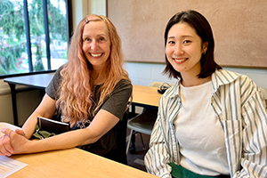 2人の女性が並んで座ってこちらを見ている様子