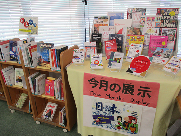 There are several books translated into 15 languages lined up on the table and the bookshelf next to it.