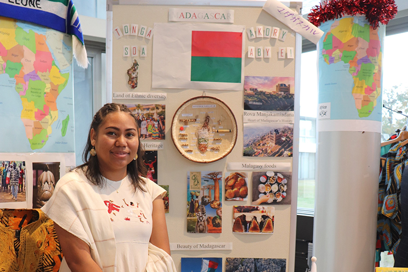 A woman is standing in front of the Madagascar booth.