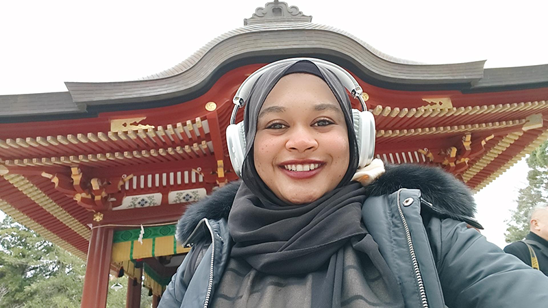 神社を背景に自撮りをしているナディア・ハラファッラー氏。