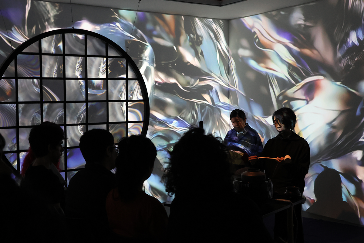 銀色の波打つような文様の壁で囲まれた空間でのパフォーマンス