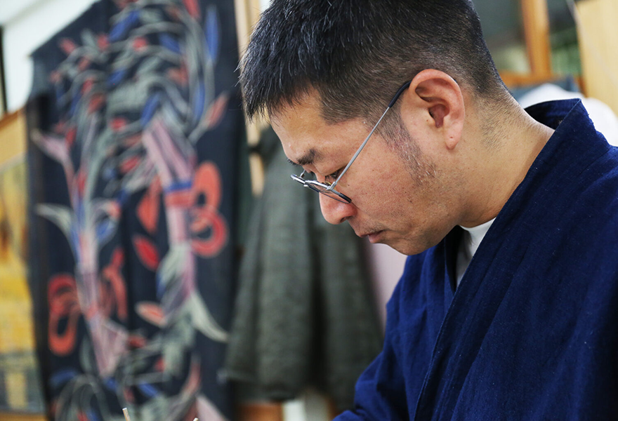 工房で、うつむき加減で作業をしている