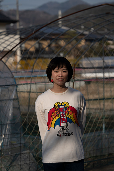 Nagara Wada is standing in front of the vinyl greenhouse.