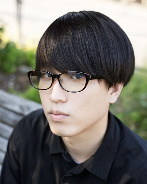 上野隆樹のポートレート。屋外でこちらを向いている。