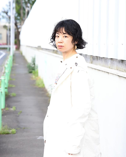 和田華子のポートレート。屋外の道でこちらを向いている。