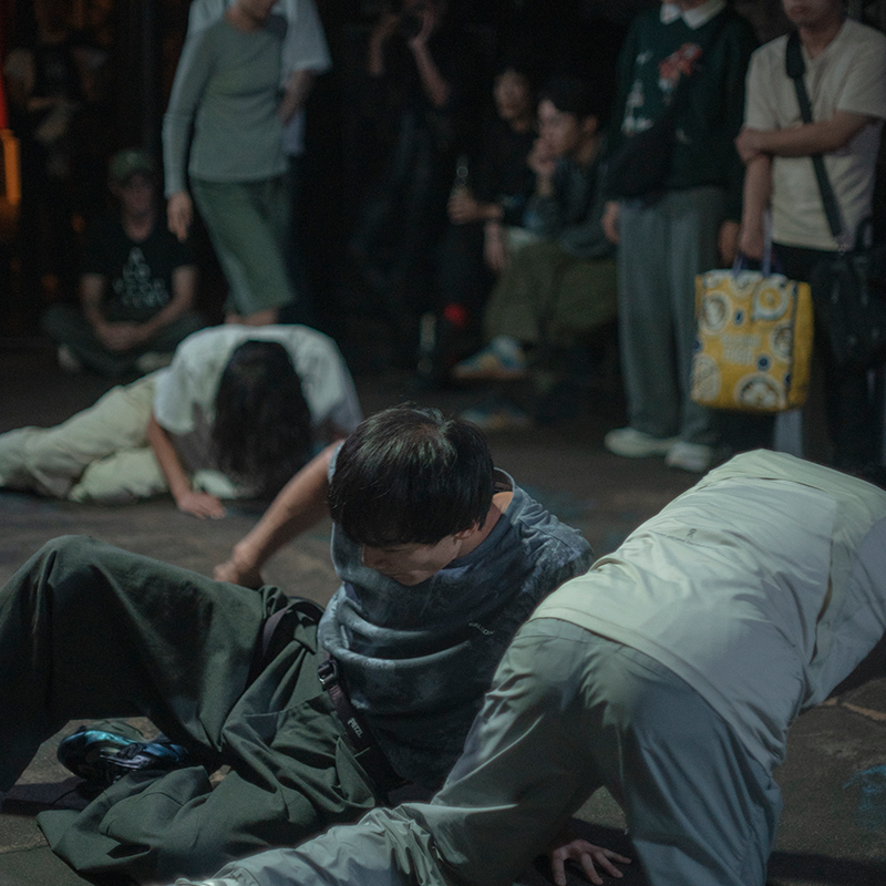 Wound and Groundのパフォーマンス風景。演者たちが地面にへたり込むような動きをしている。