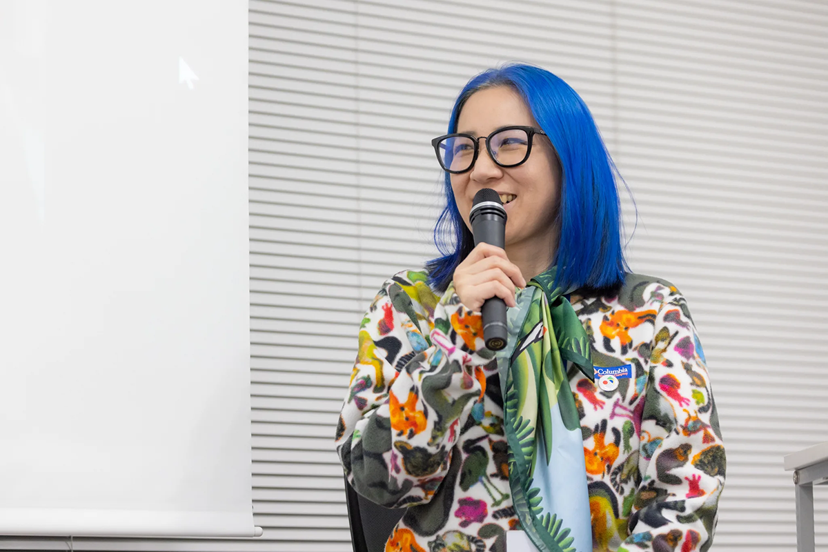 報告会の様子：マイクを持ち発言するサエボーグ氏