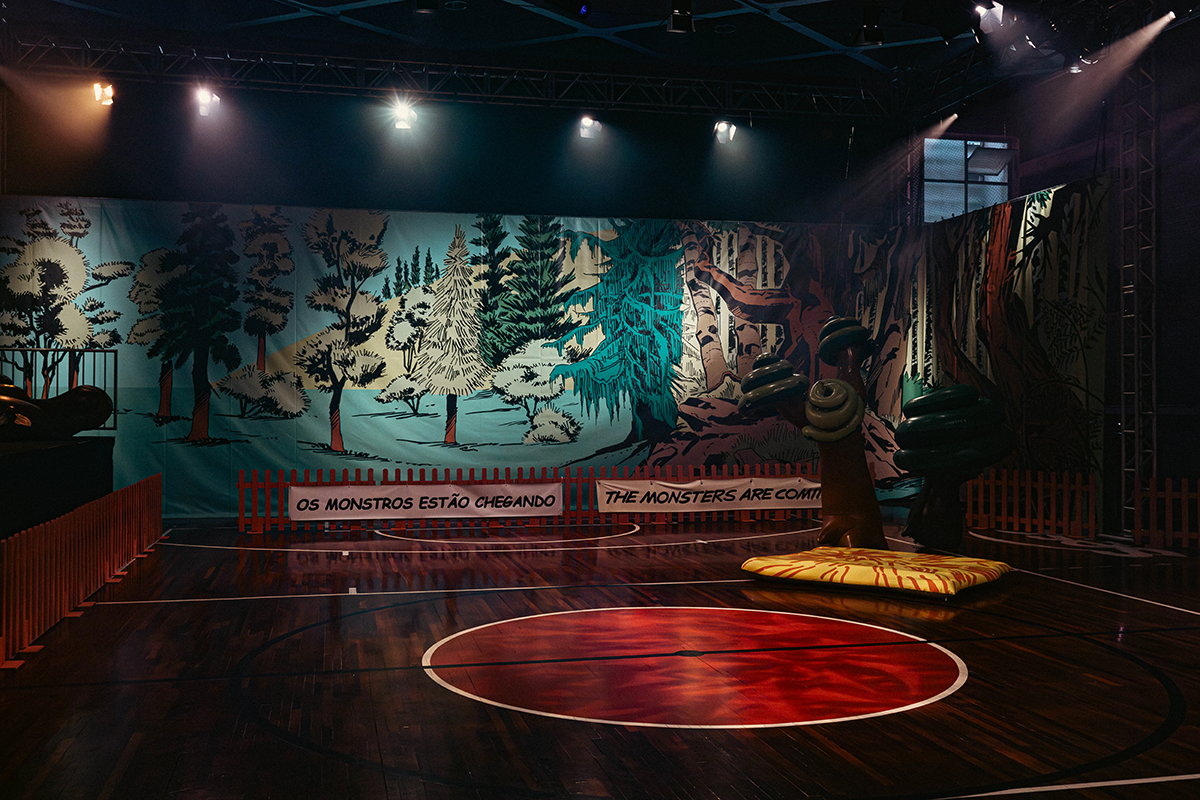 公演の様子：誰もいない舞台上、背景に怪物がやってくる、とポルトガル語と英語で書かれている