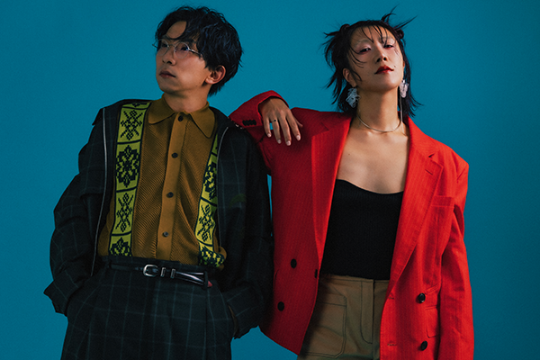 showmoreのアーティスト写真。青い背景にメンバー2人が立っている。