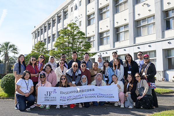 広島西条農業高等学校の校舎の前で参加者27名が写っている集合写真