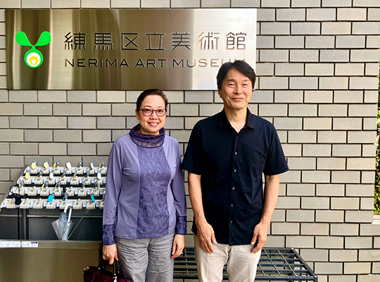 右に伊藤館長と左にヴァンペン・ケオパンニャー館長が美術館の表札の前で、並んだ記念写真
