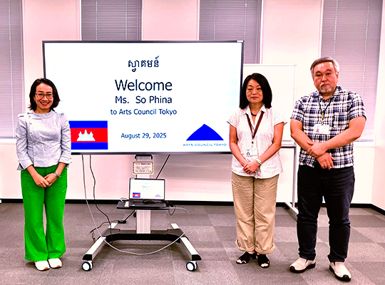 Two women and another man are standing on the right, separated by a stand display that reads 