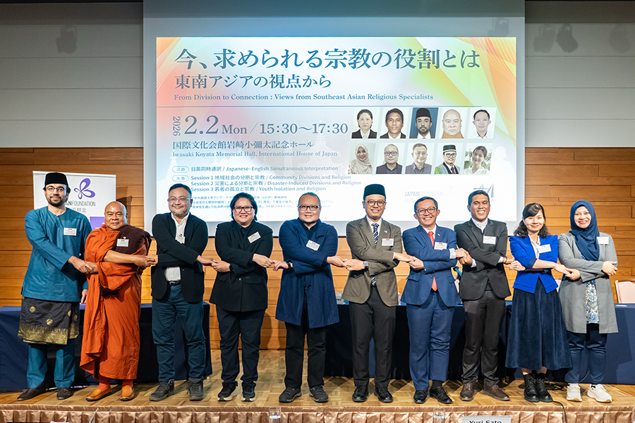 両手を交差させ隣の人と手をつないでASEANポーズで記念撮影をする参加者