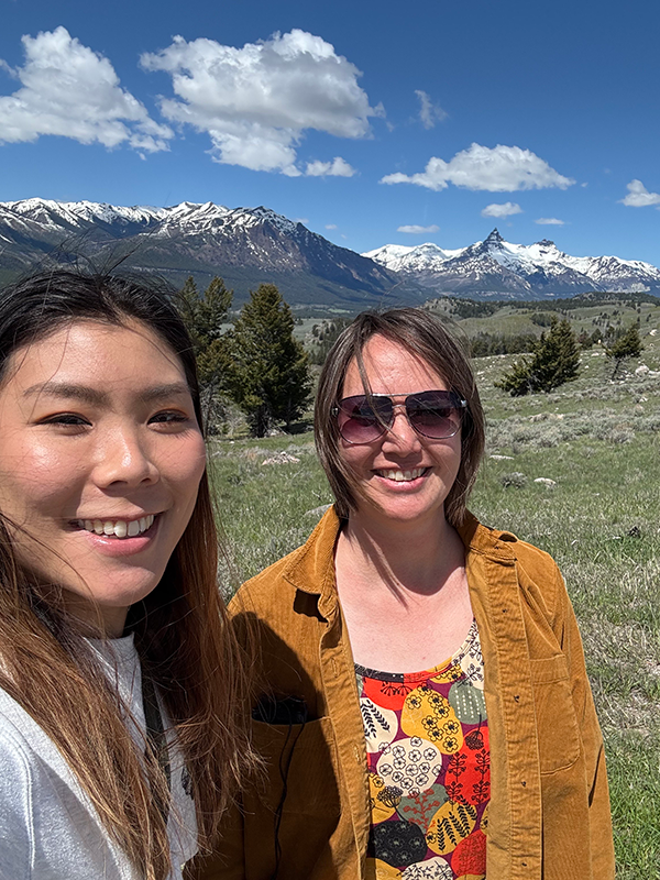 山岳を背景に、高久さんと女性1名が写っている。