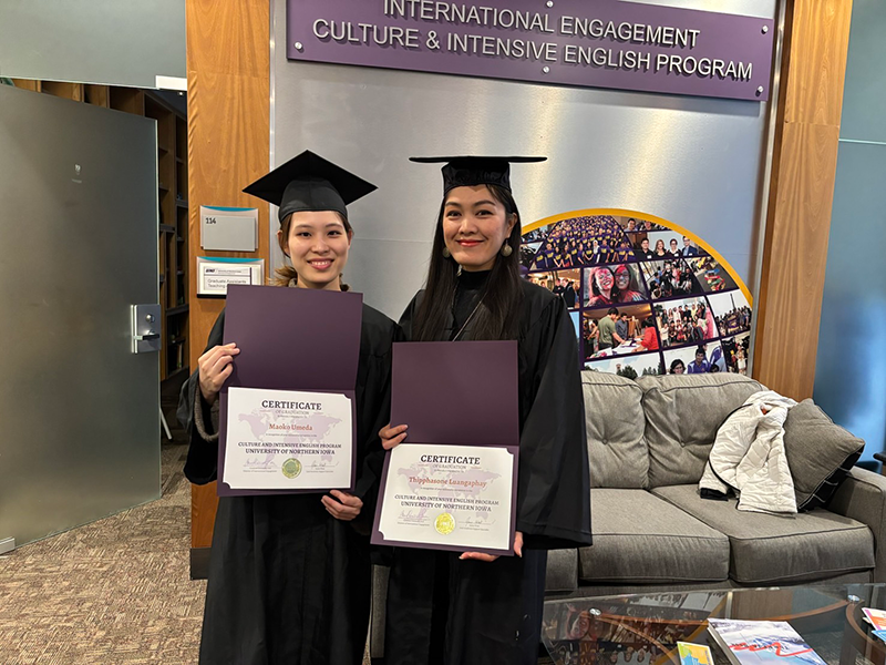 屋内にてアカデミックドレスを梅田さんと女性1名が写っている。