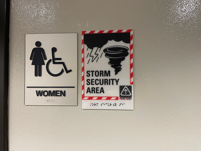 竜巻発生時の避難場所であることがわかるプレートがトイレに貼られている