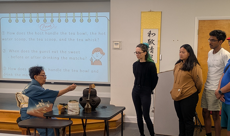 茶道の先生のデモンストレーションを見学している参加者たち