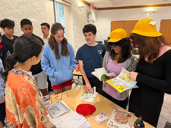 地元の高校生たちが日本の学校用品を手に取り見ている