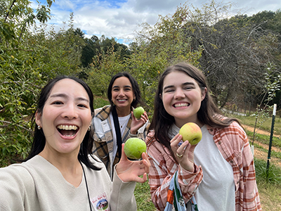 収穫したリンゴを持って友人たちと撮影