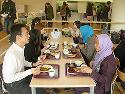 見市建氏と岩手県立大学での学生食堂を体験する2010年度の参加者の写真