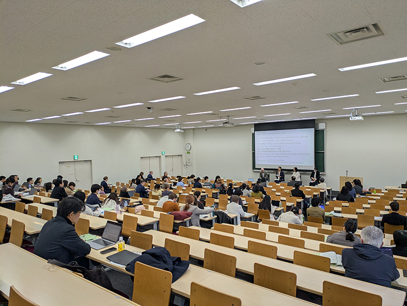 Standing at the university lecture hall, a discussion is taking place.