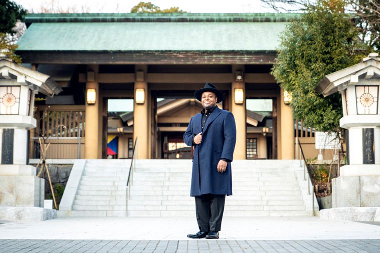 神社の前に立つクリス・ハートさん