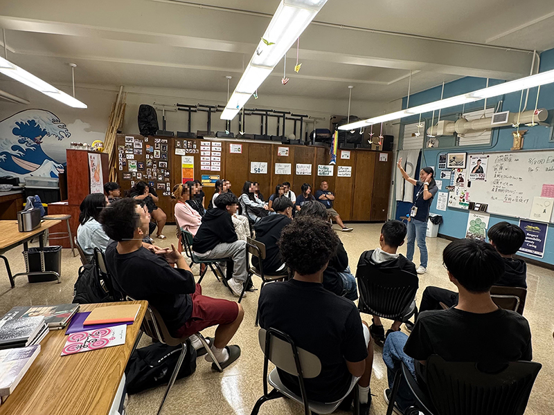 派遣先であるワイパフ・ハイ・スクールの教室にて、約20名の生徒に向かって話している後藤千絢さん。