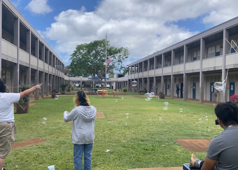 ワイパフ・ハイ・スクールの校庭で、現地の学生がシャボン玉で遊んでいる様子。