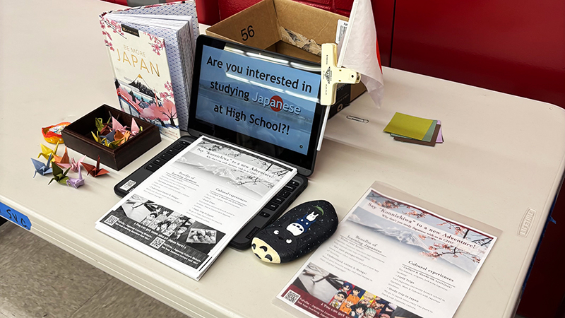 日本に関する資料が開かれているパソコンやチラシ、折り鶴などが置かれているテーブル。