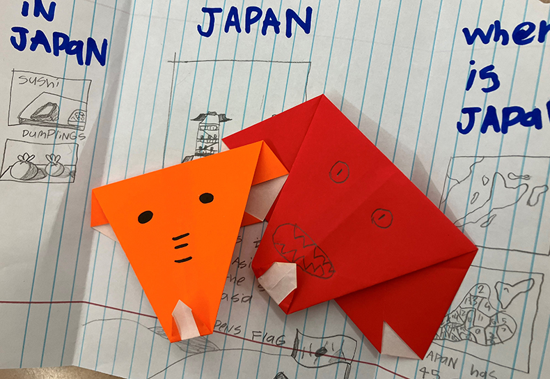 ノートの上に、象のおりがみが2つ置かれている。