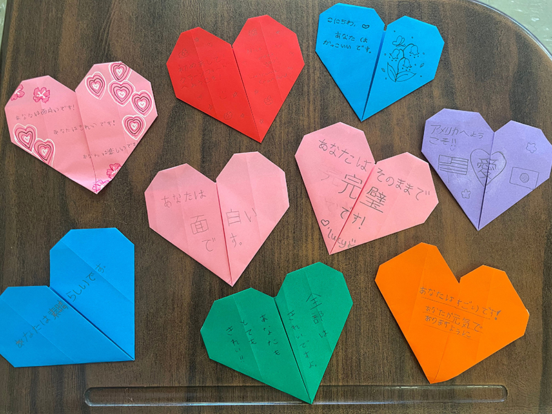 ハートに折られている9つの折り紙に、それぞれ誉め言葉が書いてある。
