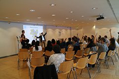 The picture of students raise their hands in response to the question, “Who here has been to Osaka?”