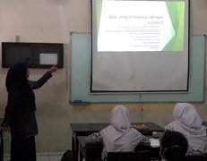 The picture of students listening attentively to the teacher explaining the rules of Tadoku reading