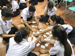 Picture of Tackling Karuta, (traditional Japanese playing cards) under the guidance of a NIHONGO Partner