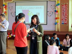 The picture of a teacher giving a message card at the JHS Student Camp