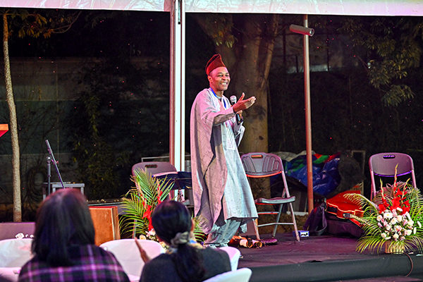 民族衣装の男性がマイクを持ち話している