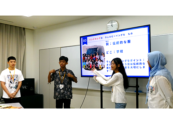 インドネシアの高校生4人が、スクリーンの左右に2人ずつ立って、自国のウェルビーイングなものについて発表している